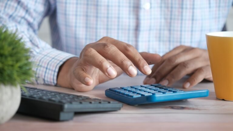 Empleador calculando aportes con una calculadora