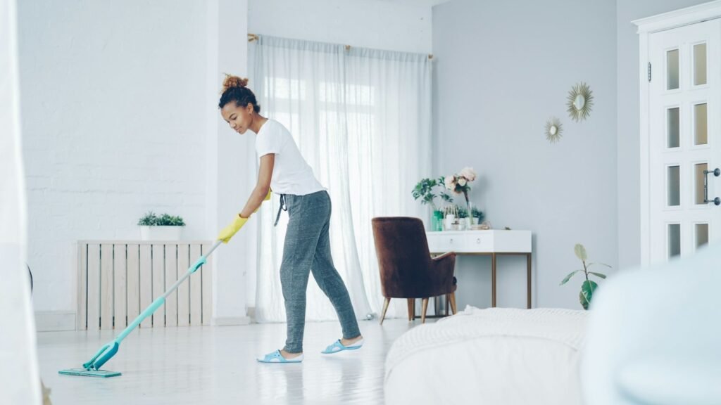 Trabajadora del servicio doméstico limpiando el piso de una casa